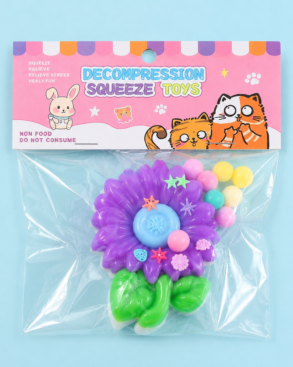 a purple flower-shaped decompression squishy toy with glossy petals, green leaves, mini decorative accents, and pastel pom poms