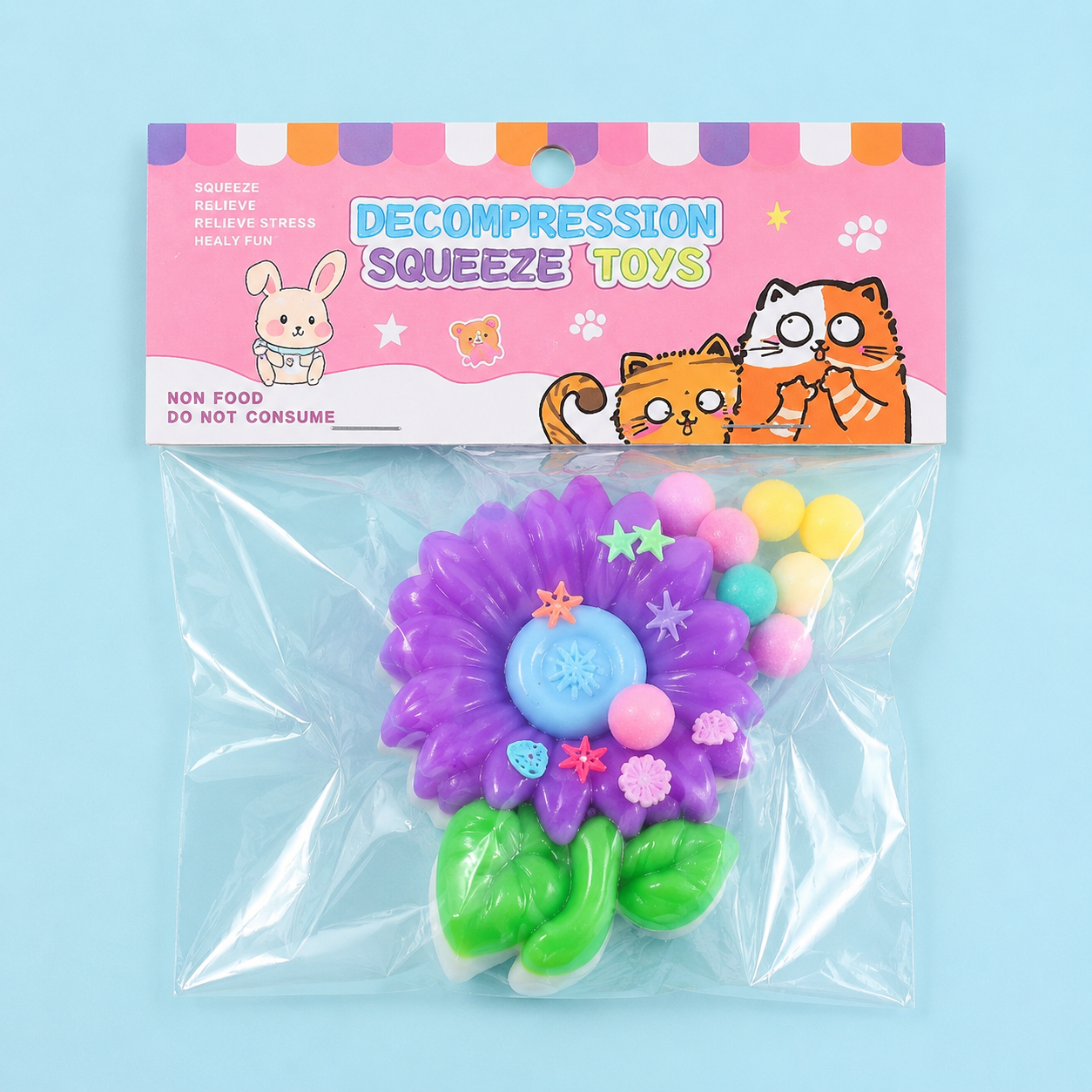 a purple flower-shaped decompression squishy toy with glossy petals, green leaves, mini decorative accents, and pastel pom poms