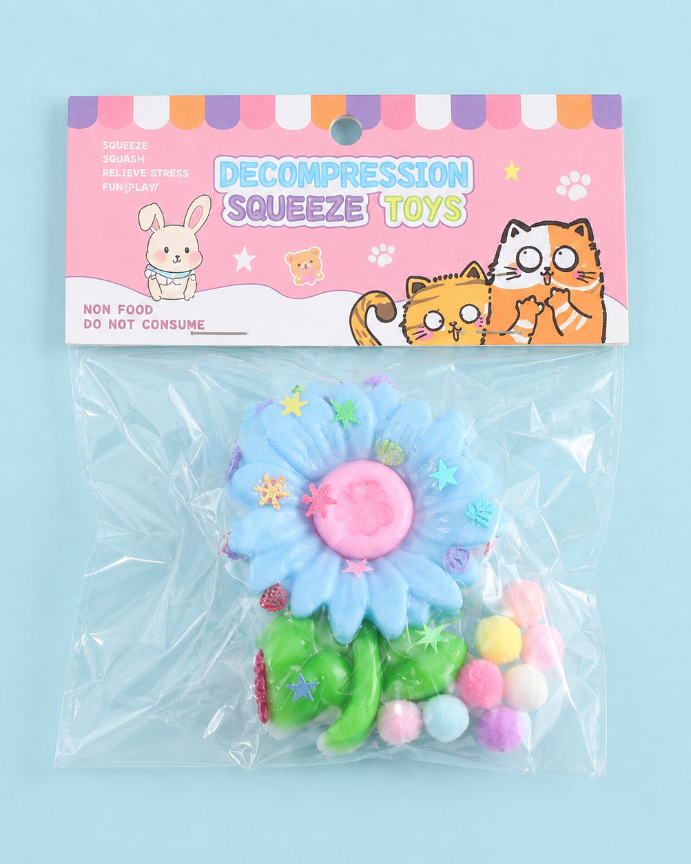 a blue flower-shaped decompression squishy toy with glossy petals, green leaves, mini decorative accents, and pastel pom poms