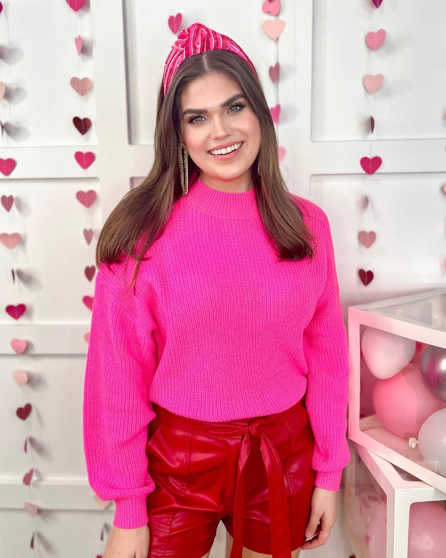 a pink long sleeve sweater with a drop-shoulder for a relaxed fit, a crew neckline, and a ribbed hemline on a textured ultra-soft design fabric