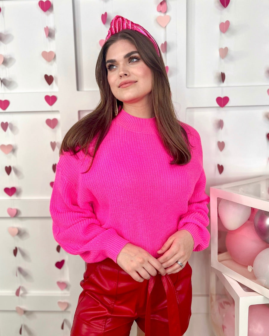 a pink long sleeve sweater with a drop-shoulder for a relaxed fit, a crew neckline, and a ribbed hemline on a textured ultra-soft design fabric