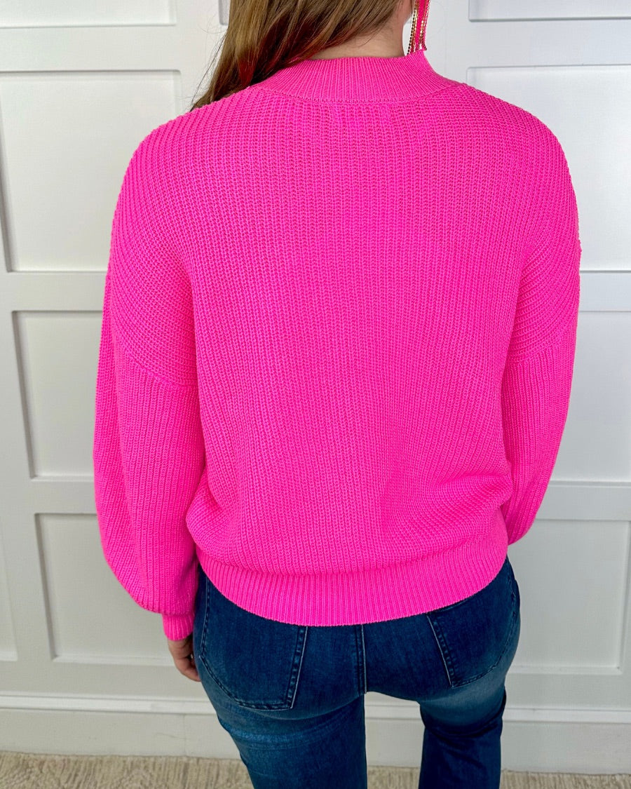a pink long sleeve sweater with a drop-shoulder for a relaxed fit, a crew neckline, and a ribbed hemline on a textured ultra-soft design fabric