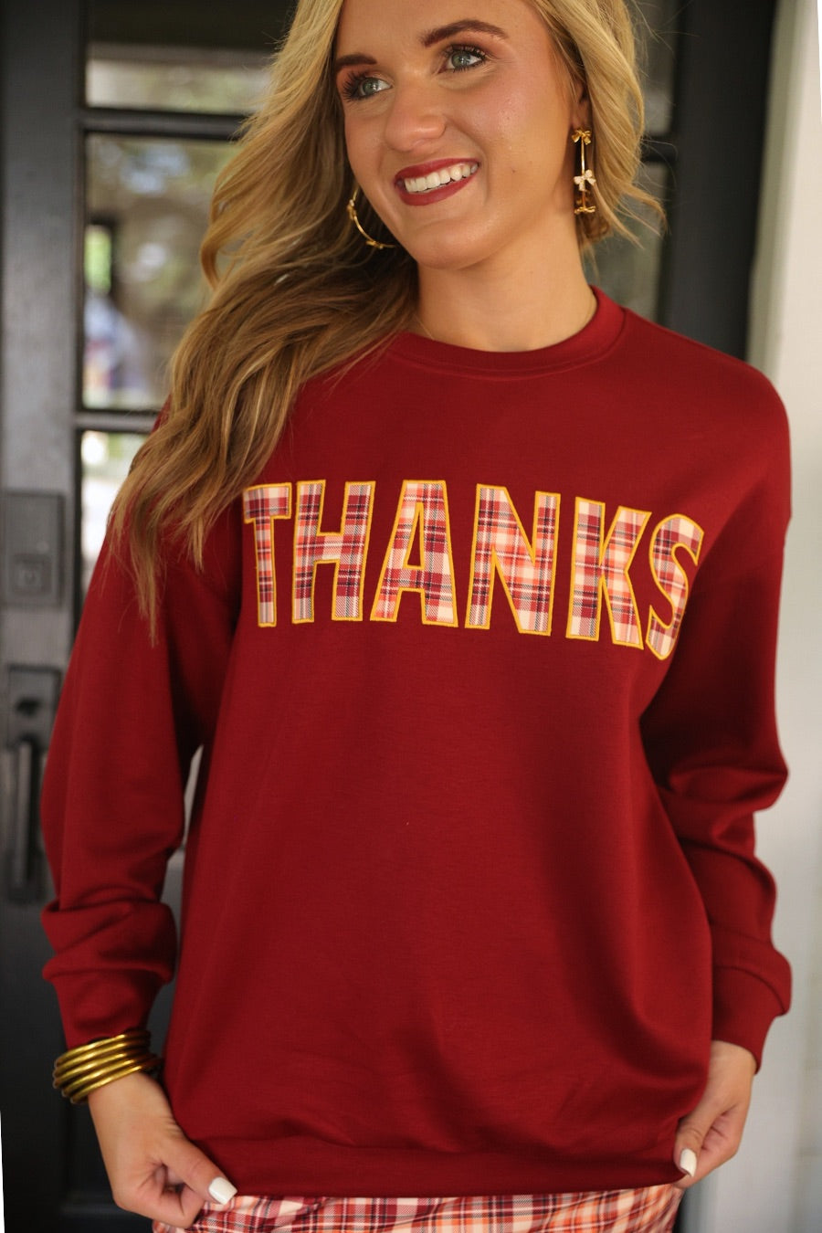 long-sleeve burgundy pullover with plaid 'THANKS' letters outlined in embroidery on a soft fabric
