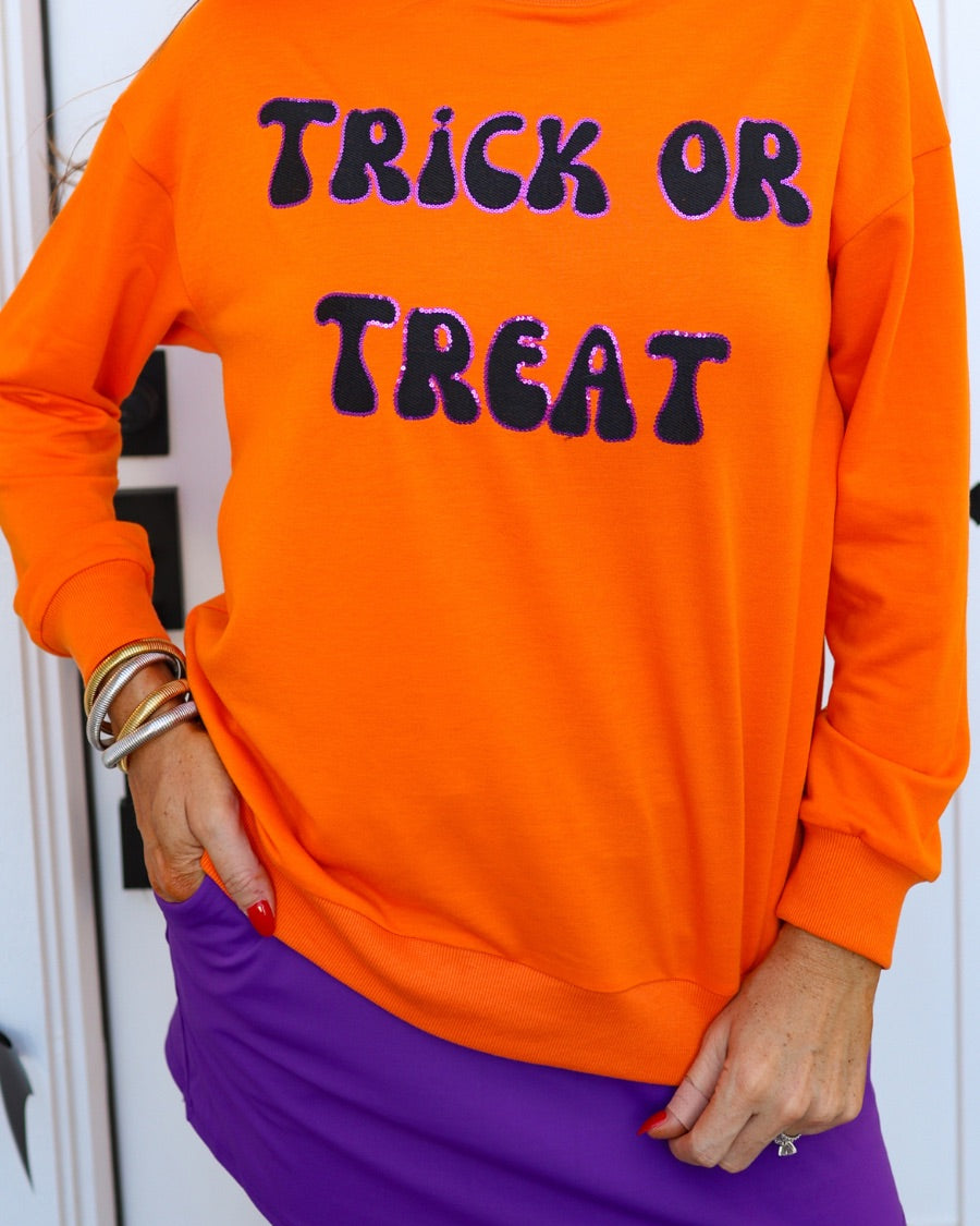 a long-sleeve sweatshirt with plush black embroidered 'TRICK OR TREAT' appliquรฉ lettering, purple sequin outlining, crew neckline, ribbed cuffs, a banded hem, and a relaxed fit for a classic silhouette