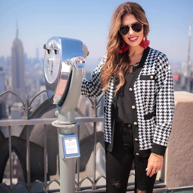 long sleeve jacket with a front gold button closure, contrasting trim on the pockets and edges, pockets (two faux, two functional), and a collared neckline on a black and ivory houndstooth print