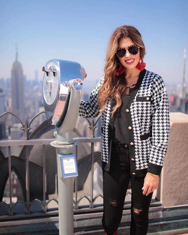 long sleeve jacket with a front gold button closure, contrasting trim on the pockets and edges, pockets (two faux, two functional), and a collared neckline on a black and ivory houndstooth print