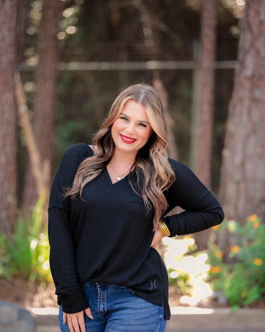 made in the USA long-sleeve top crafted from soft material with waffle knit texturing, a drop shoulder, a v-neck neckline, a front chest pocket, a hi-low side split hem, and a relaxed fit that falls into a straight hemline in black