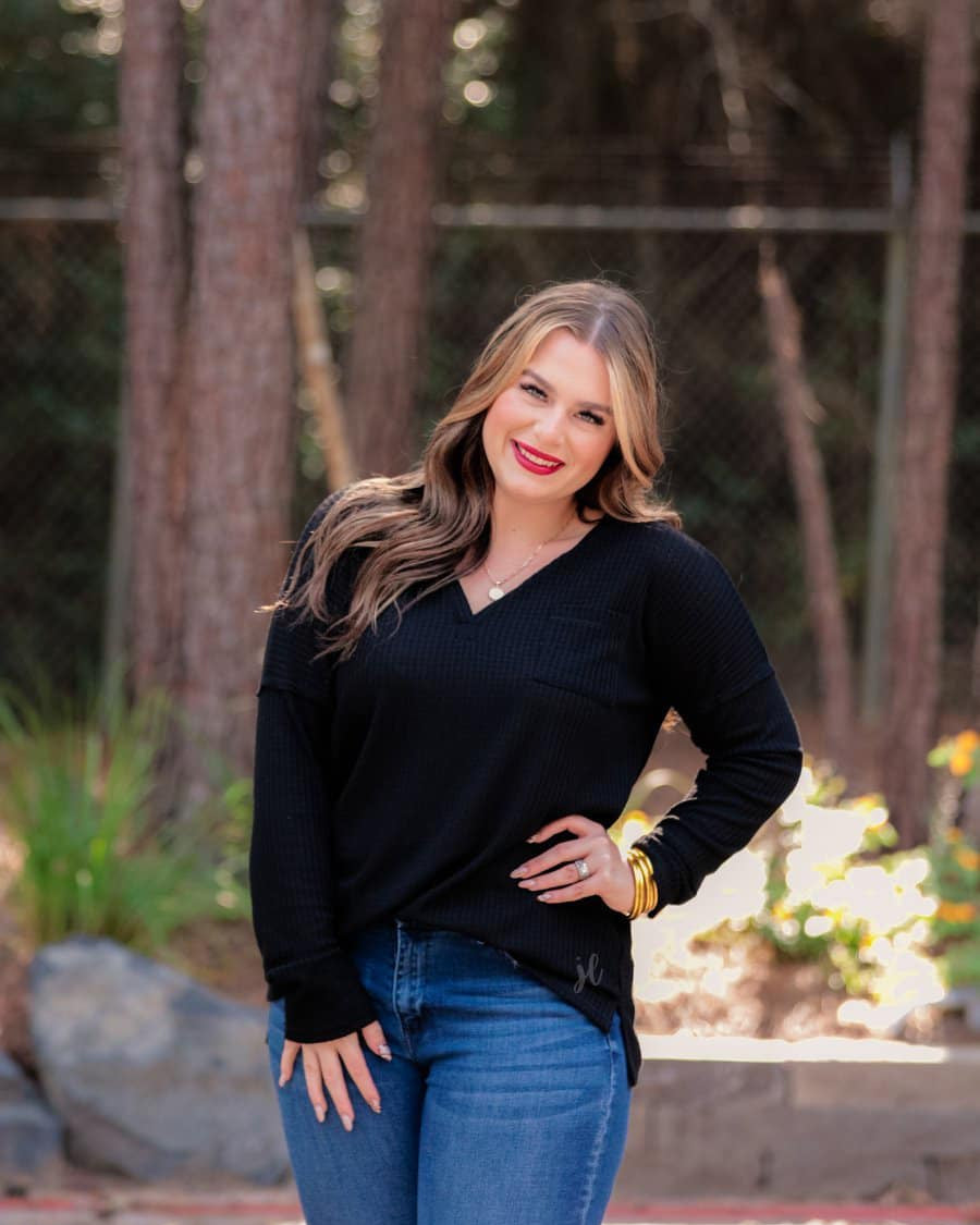 made in the USA long-sleeve top crafted from soft material with waffle knit texturing, a drop shoulder, a v-neck neckline, a front chest pocket, a hi-low side split hem, and a relaxed fit that falls into a straight hemline in black