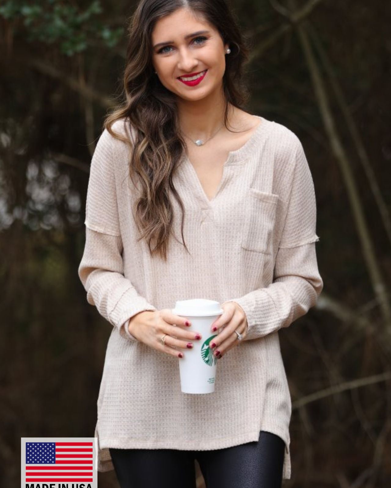 made in the USA long-sleeve top crafted from soft material with waffle knit texturing, a drop shoulder, a v-neck neckline, a front chest pocket, a hi-low side split hem, and a relaxed fit that falls into a straight hemline in oatmeal