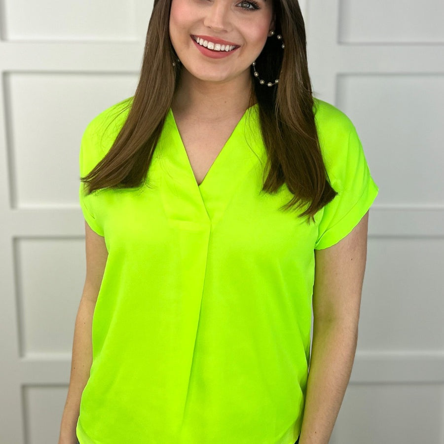 a vibrant neon lime blouse made of lightweight woven fabric blouse with a flattering draped silhouette, a contemporary V-neckline, rolled short sleeves, a fully lined interior, and no stretch