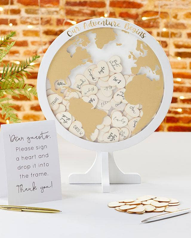 World map decoration with heart-shaped cutouts and a sign on a table.