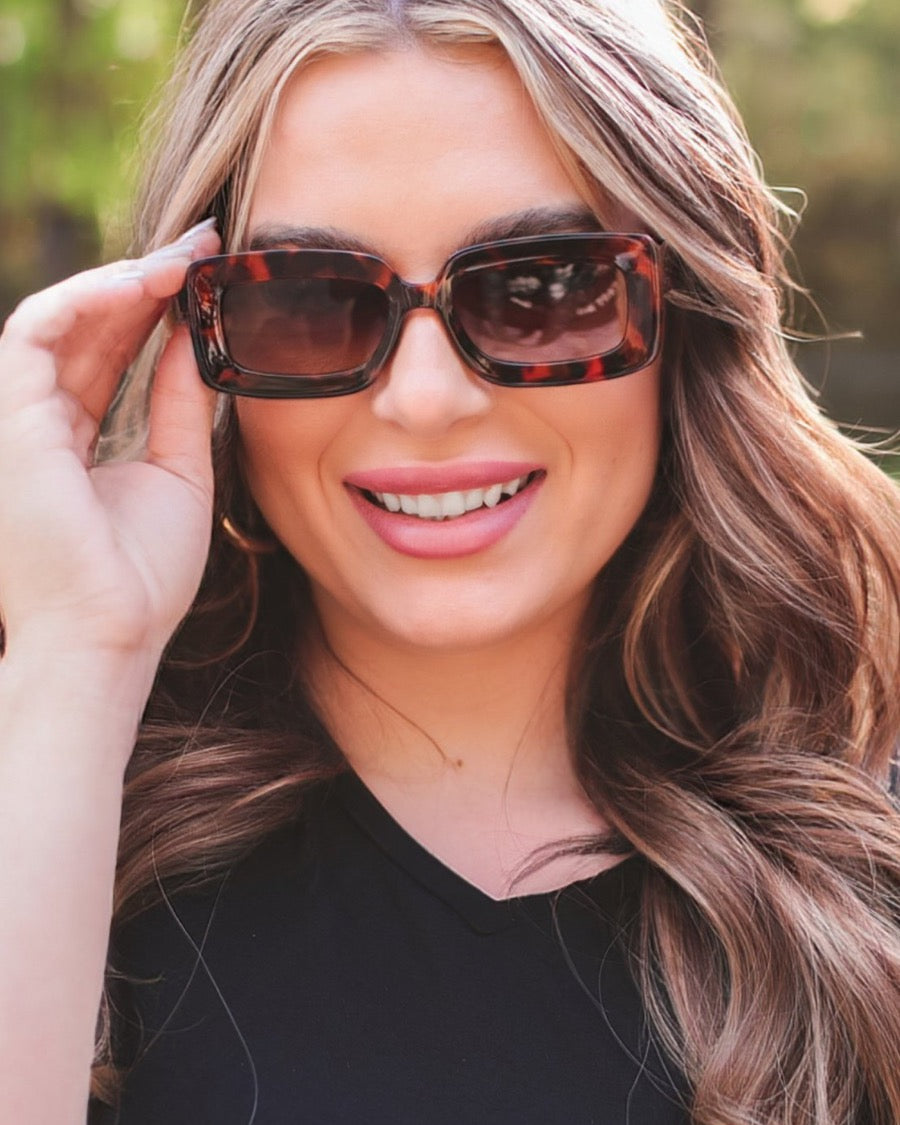 brown chunky rectangular sunglasses with thick frames, tinted lenses, smooth finish, UV protection, and brand detail (on both the temple and the complimentary black pouch)