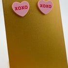 ink candy heart-inspired earrings shaped like hearts with 'XOXO' lettering in the center