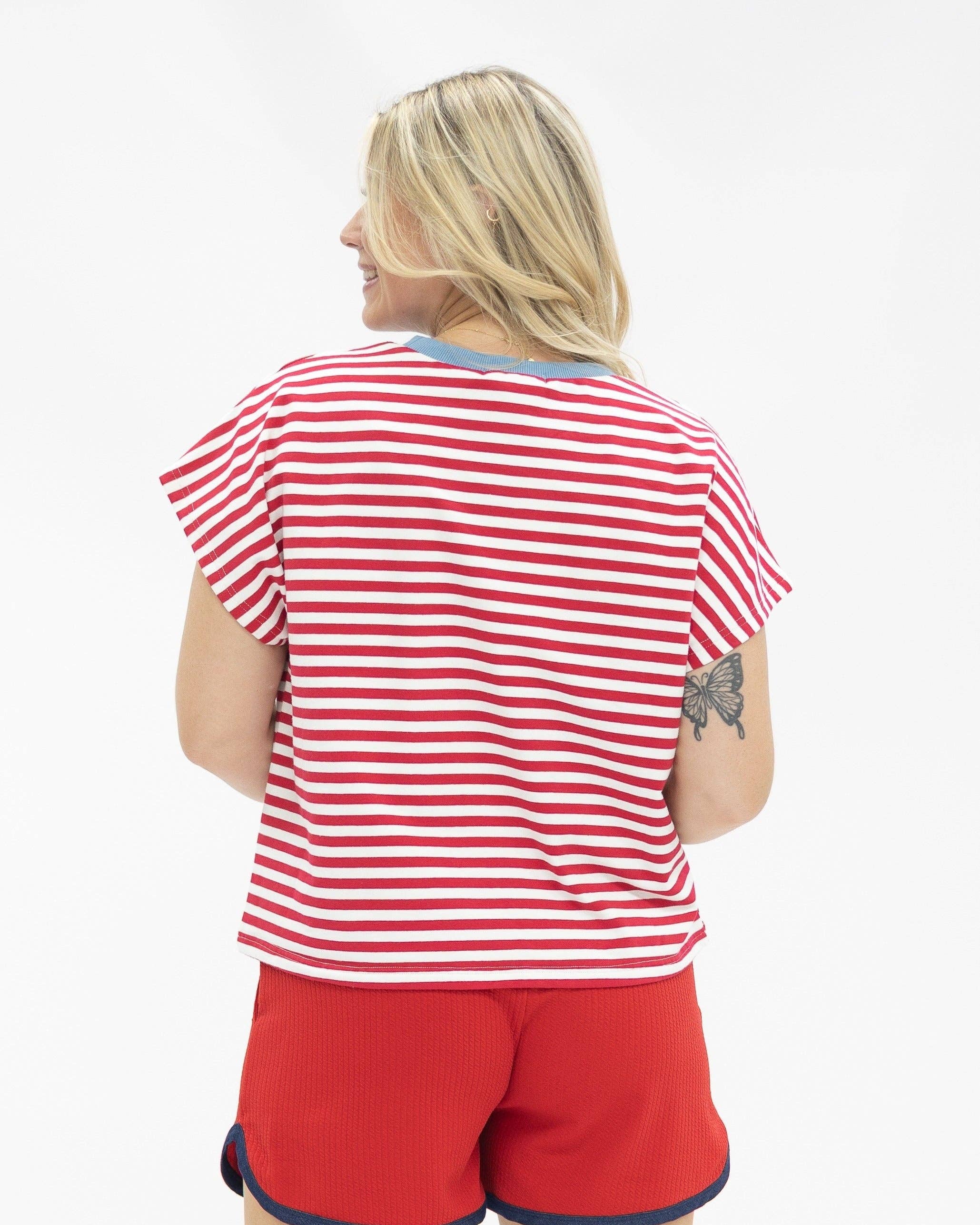 a high-stretch oversized short-sleeve stripe top with a crew neckline, a horizontal stripe pattern (red and white), bold denim 1776 patch detail, tiny star accents, a relaxed easy drape, and unlined