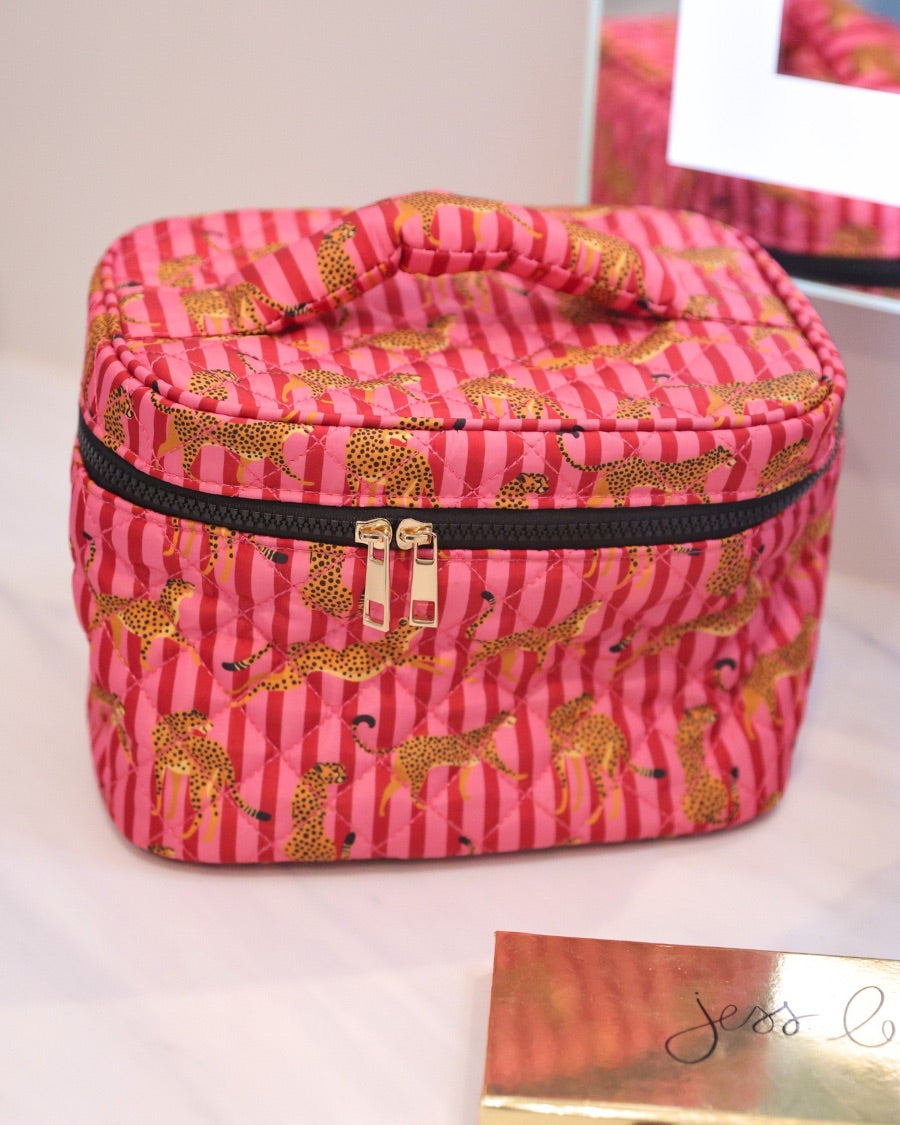 a structured bag with a spacious interior, a secure double zip around closure, a top handle, and gold accents on a quilted body in savannah soirée (pink/raspberry)