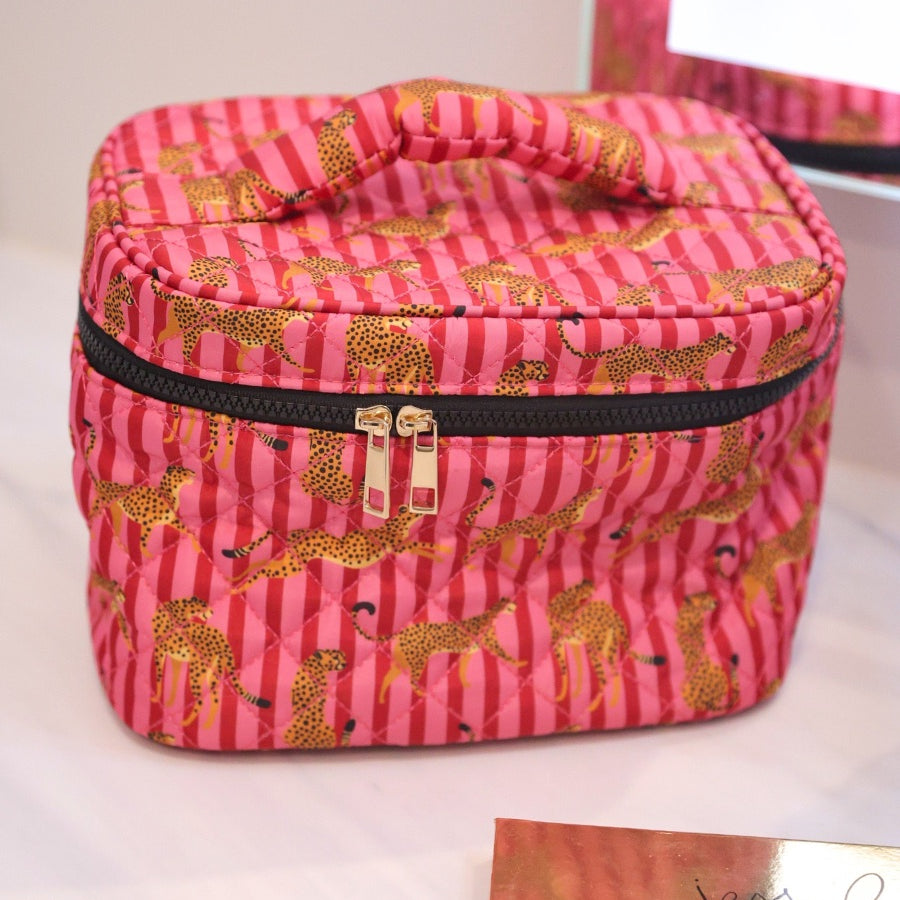 a structured bag with a spacious interior, a secure double zip around closure, a top handle, and gold accents on a quilted body in savannah soirée (pink/raspberry)