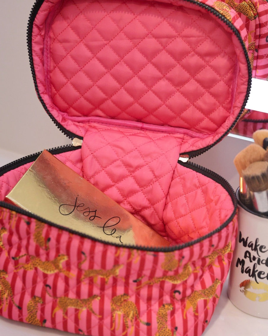 a structured bag with a spacious interior, a secure double zip around closure, a top handle, and gold accents on a quilted body in savannah soirée (pink/raspberry)