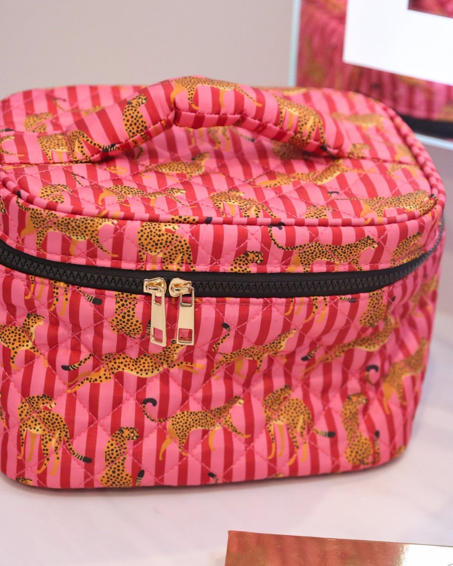 a structured bag with a spacious interior, a secure double zip around closure, a top handle, and gold accents on a quilted body in savannah soirée (pink/raspberry)