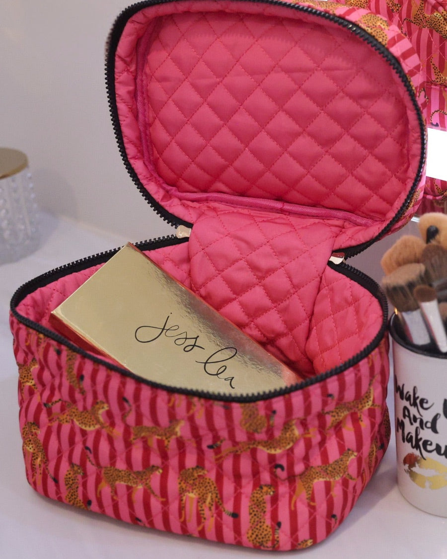 a structured bag with a spacious interior, a secure double zip around closure, a top handle, and gold accents on a quilted body in savannah soirée (pink/raspberry)