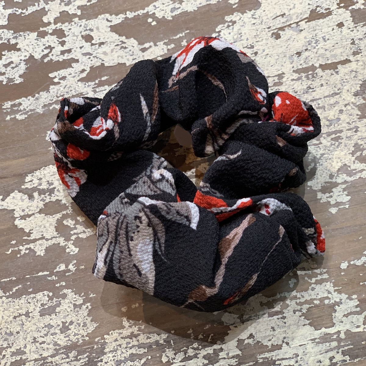 an oversized floral scrunchie with lightweight textured fabric, gathered construction, gentle hair-friendly hold, and easy pull-on styling in black