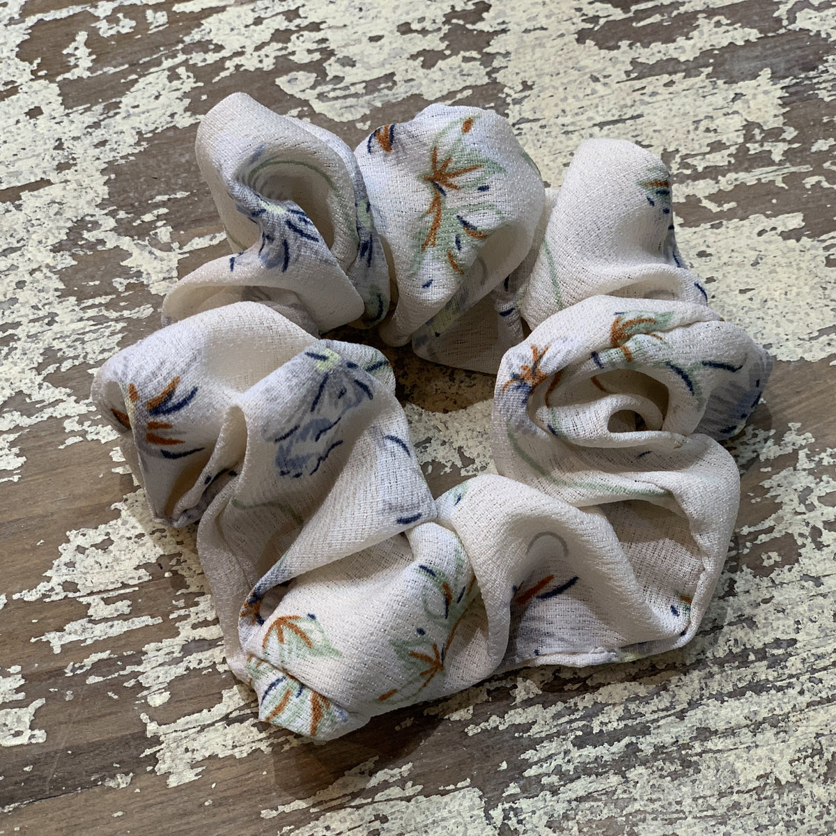 an oversized floral scrunchie with lightweight textured fabric, gathered construction, gentle hair-friendly hold, and easy pull-on styling in cream