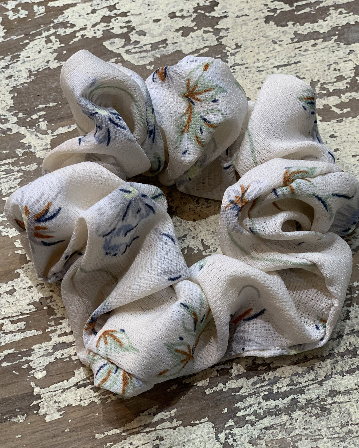 an oversized floral scrunchie with lightweight textured fabric, gathered construction, gentle hair-friendly hold, and easy pull-on styling in cream