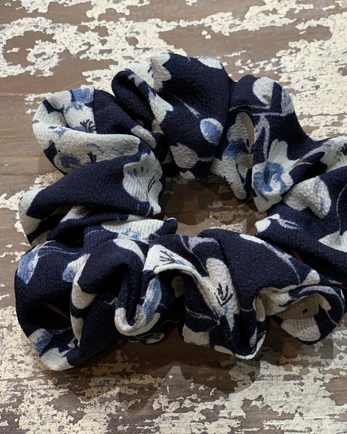 an oversized floral scrunchie with lightweight textured fabric, gathered construction, gentle hair-friendly hold, and easy pull-on styling in navy cream