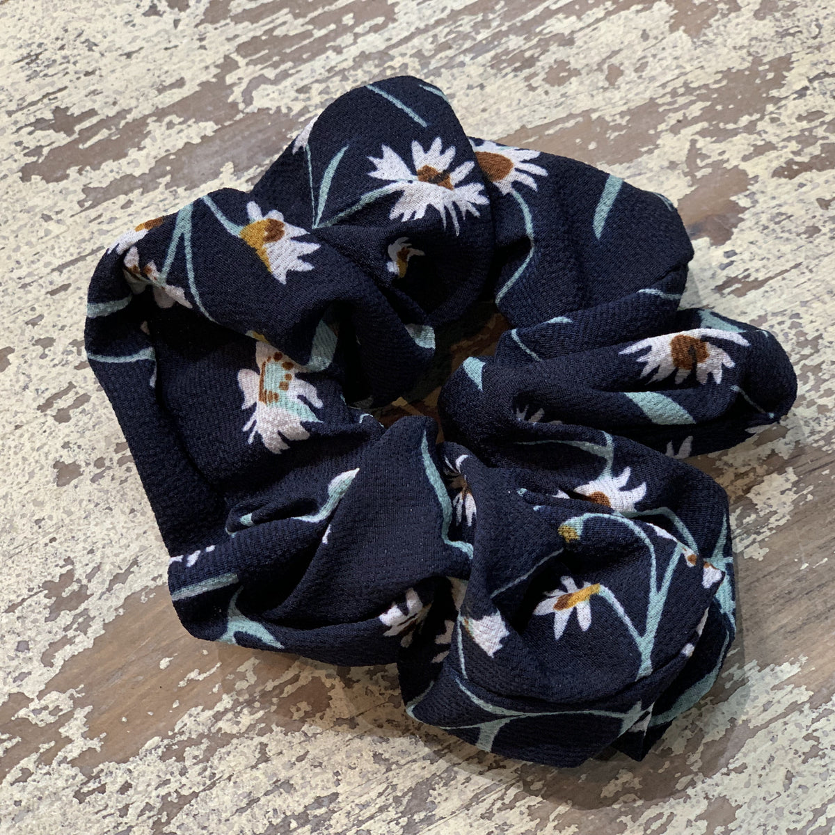 an oversized floral scrunchie with lightweight textured fabric, gathered construction, gentle hair-friendly hold, and easy pull-on styling in navy teal