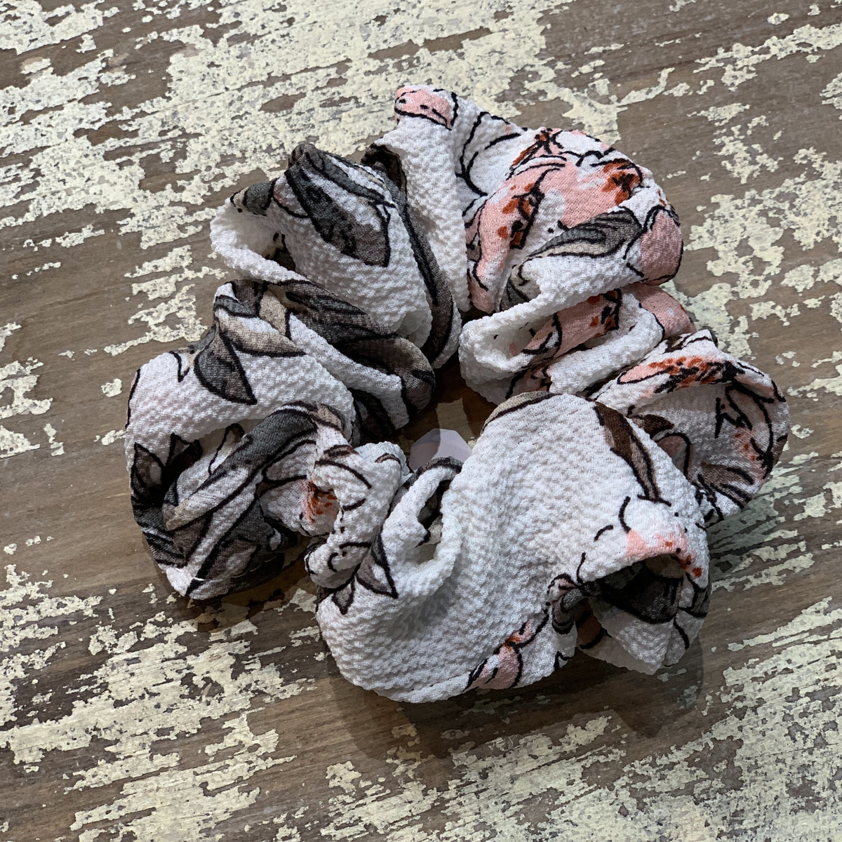 an oversized floral scrunchie with lightweight textured fabric, gathered construction, gentle hair-friendly hold, and easy pull-on styling in white