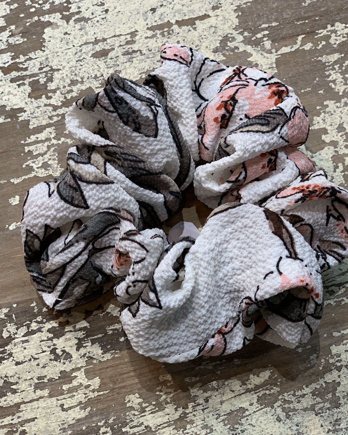 an oversized floral scrunchie with lightweight textured fabric, gathered construction, gentle hair-friendly hold, and easy pull-on styling in white
