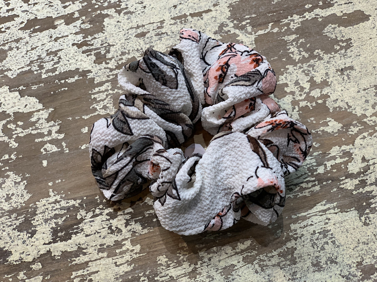 an oversized floral scrunchie with lightweight textured fabric, gathered construction, gentle hair-friendly hold, and easy pull-on styling in white