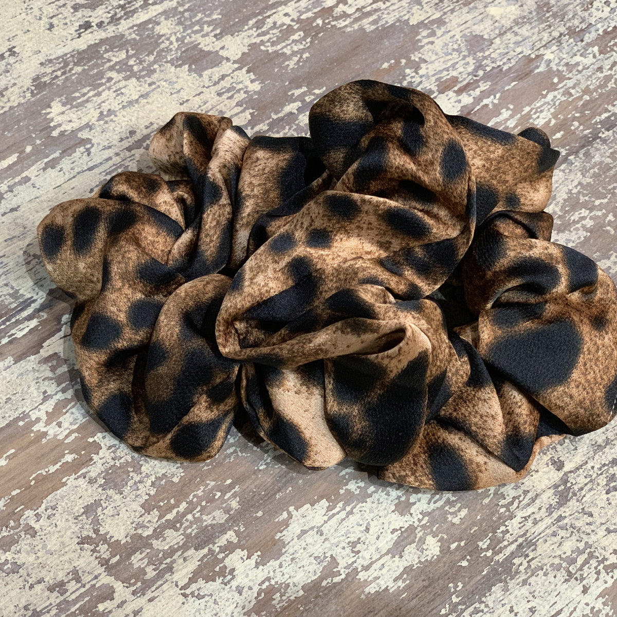 an oversized satin-look leopard scrunchie with glossy animal print fabric, plush gathered construction, lightweight feel, and gentle hair-friendly hold in leopard chocolate