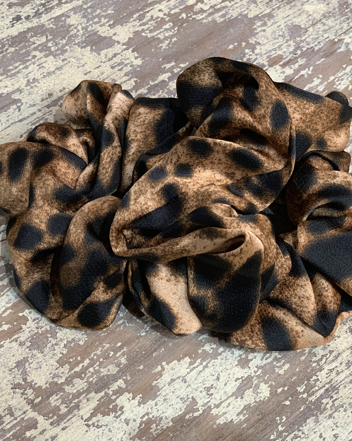 an oversized satin-look leopard scrunchie with glossy animal print fabric, plush gathered construction, lightweight feel, and gentle hair-friendly hold in leopard chocolate
