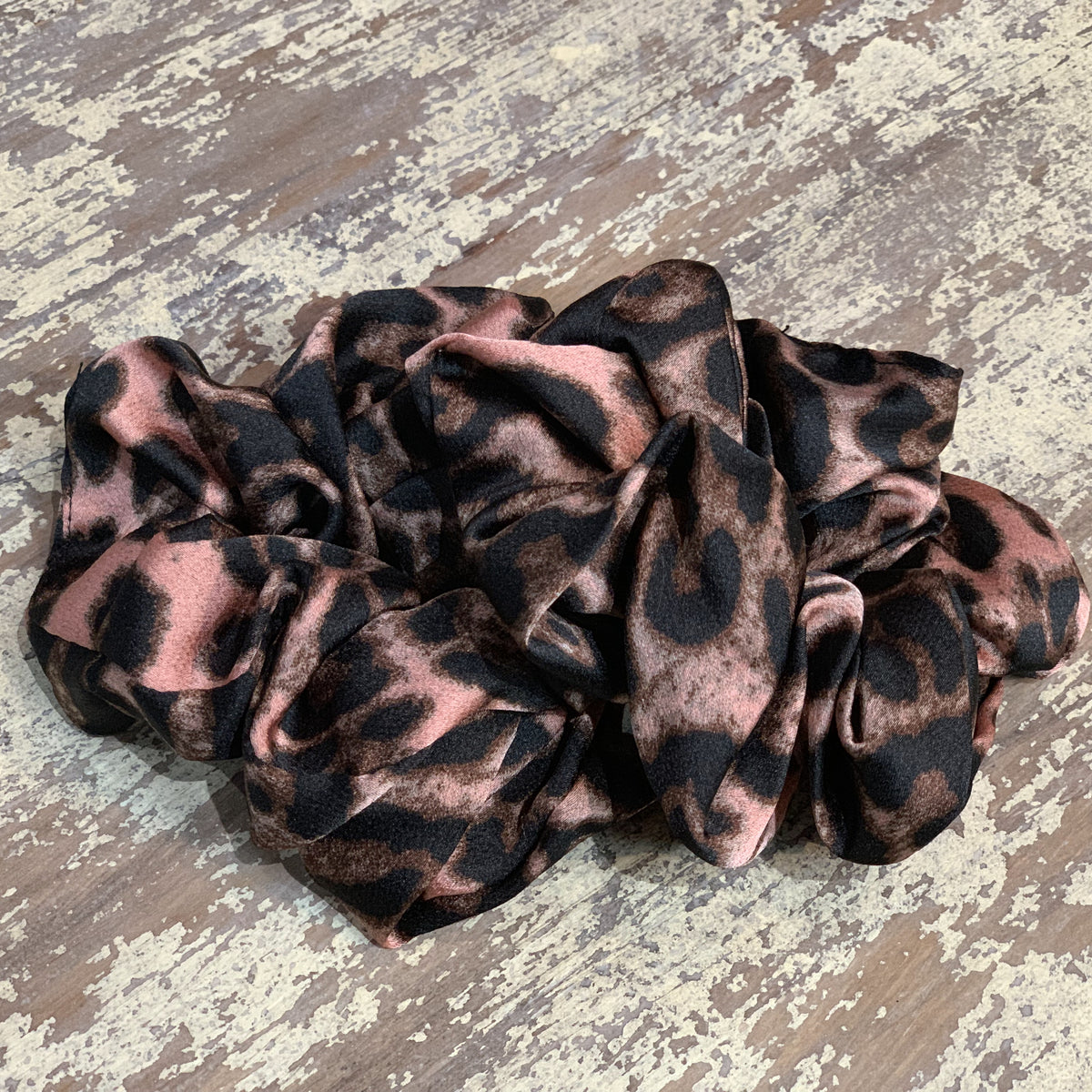 an oversized satin-look leopard scrunchie with glossy animal print fabric, plush gathered construction, lightweight feel, and gentle hair-friendly hold in leopard mauve