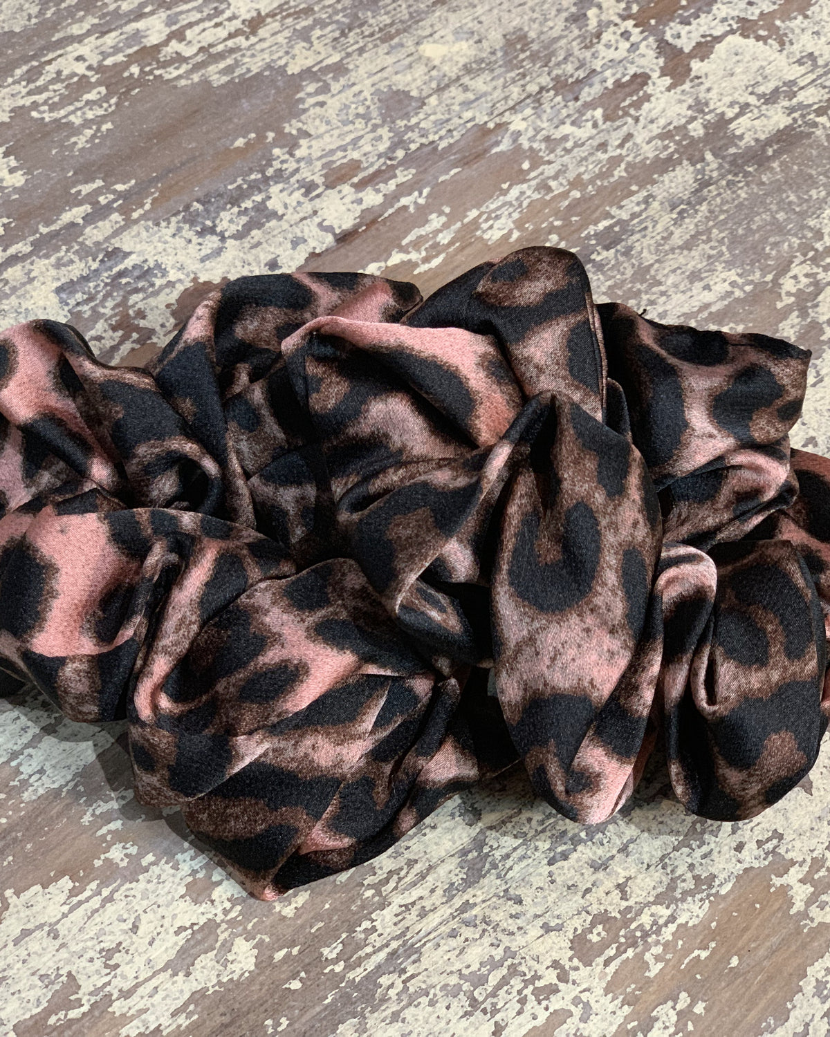 an oversized satin-look leopard scrunchie with glossy animal print fabric, plush gathered construction, lightweight feel, and gentle hair-friendly hold in leopard mauve