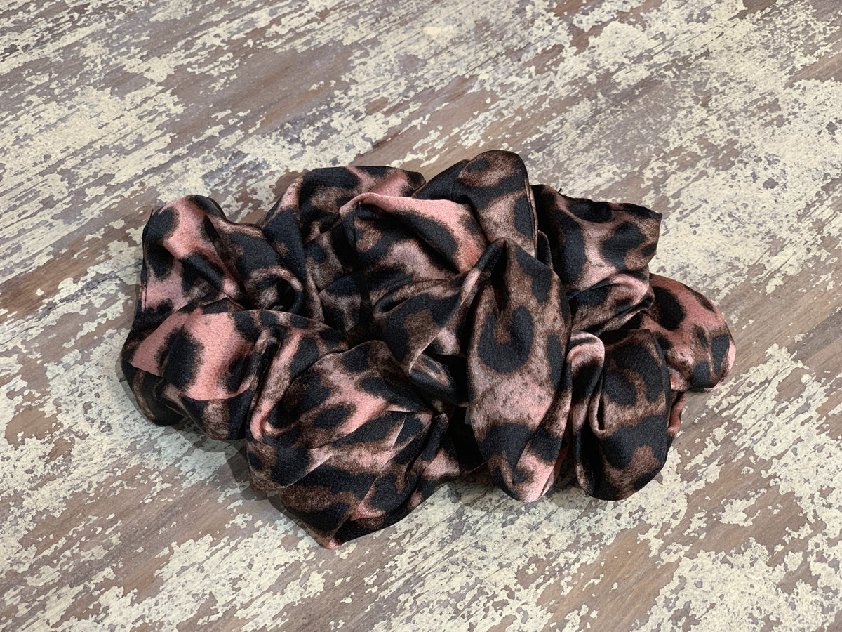 an oversized satin-look leopard scrunchie with glossy animal print fabric, plush gathered construction, lightweight feel, and gentle hair-friendly hold in leopard mauve