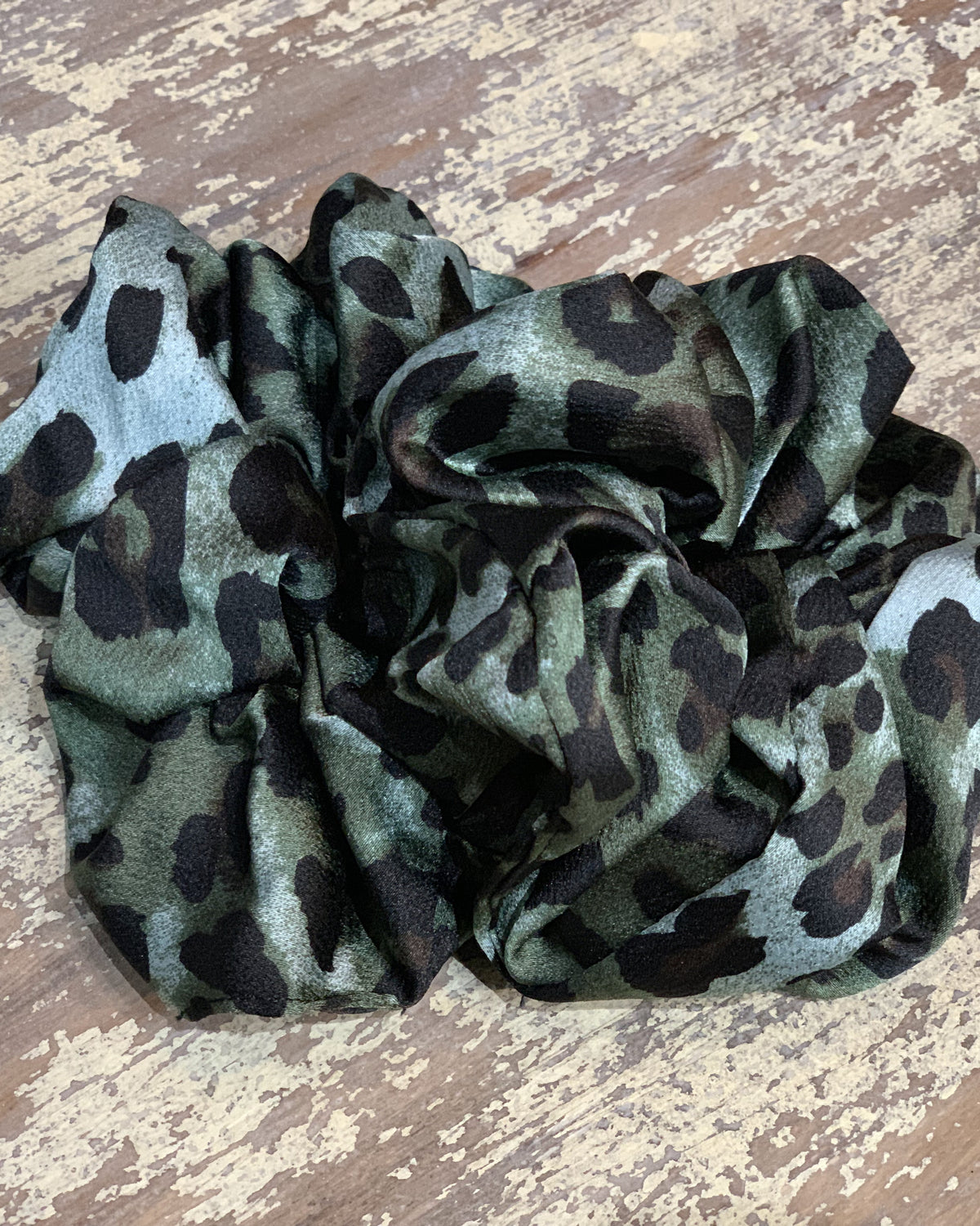 an oversized satin-look leopard scrunchie with glossy animal print fabric, plush gathered construction, lightweight feel, and gentle hair-friendly hold in leopard teal