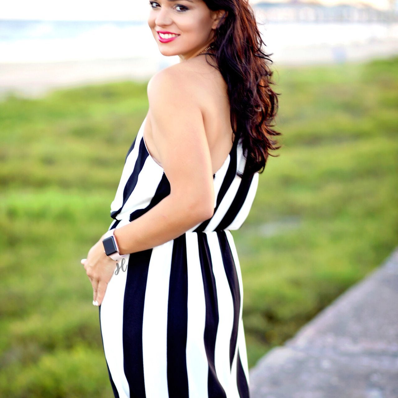 sleeveless maxi dress made of lightweight material with non-adjustable crisscross spaghetti straps, a left side slit, and interior lining, designed on a black and white vertical striped pattern fabric