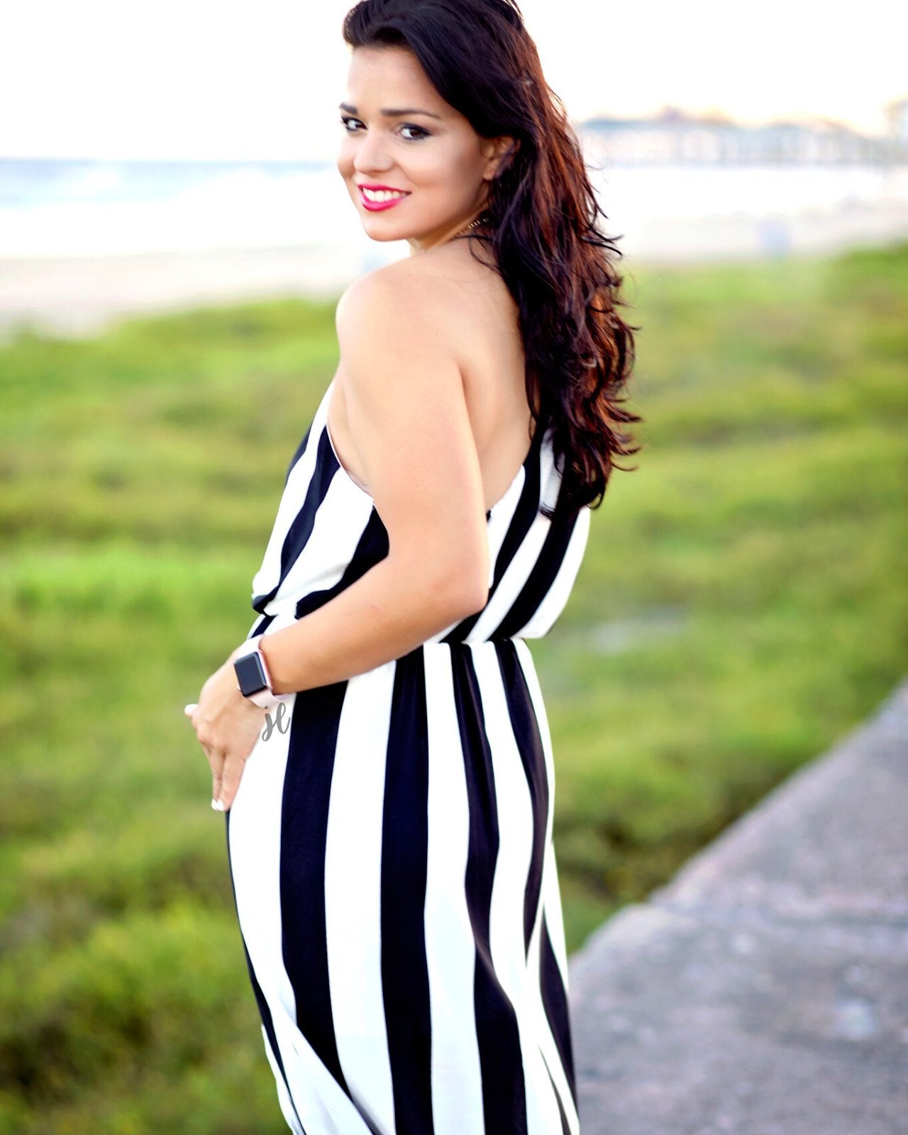 sleeveless maxi dress made of lightweight material with non-adjustable crisscross spaghetti straps, a left side slit, and interior lining, designed on a black and white vertical striped pattern fabric