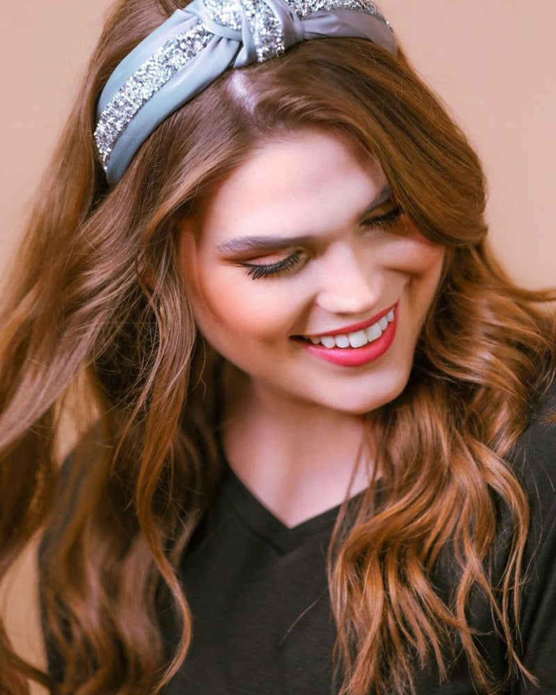 a twisted center knot with rhinestones lining the headband's center in grey
