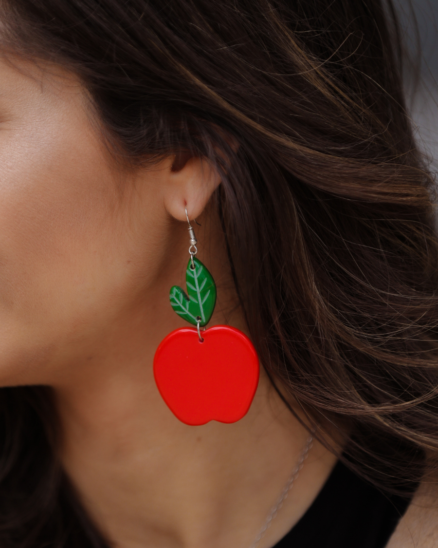 dangle earrings with a bold red apple in a glossy finish, a bright green leaf detail, and silver fish hooks