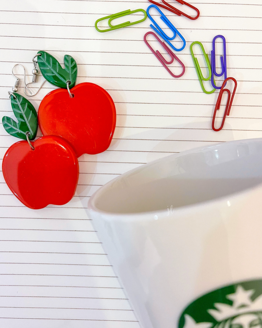 dangle earrings with a bold red apple in a glossy finish, a bright green leaf detail, and silver fish hooks