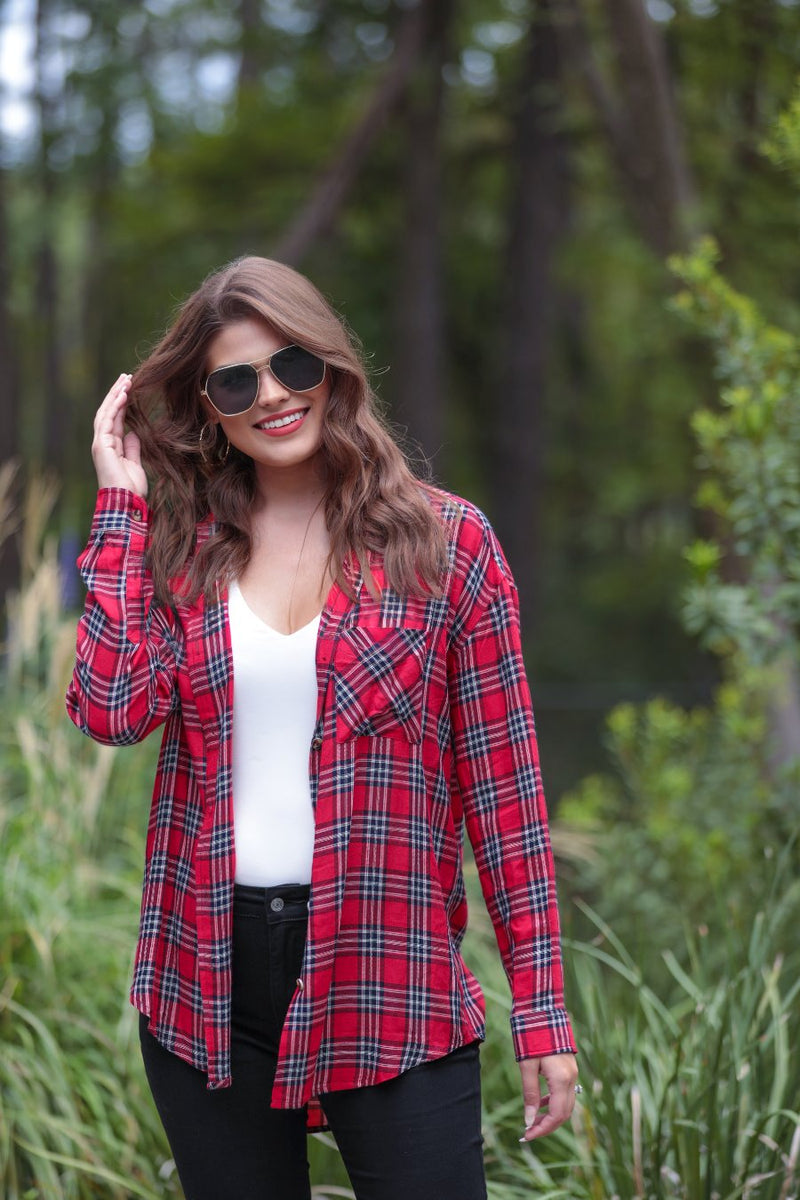 lightweight top with functional buttons, a collared neckline, roll-tab long sleeves, and a high low round hemline on a red plaid pattern