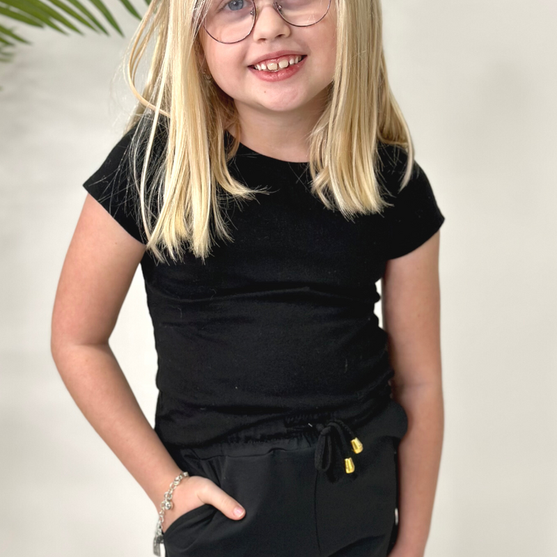 mid-rise relaxed fit activewear shorts with side pockets and a tie waist drawstring with gold bead accents, designed on a solid black print fabric and black trim