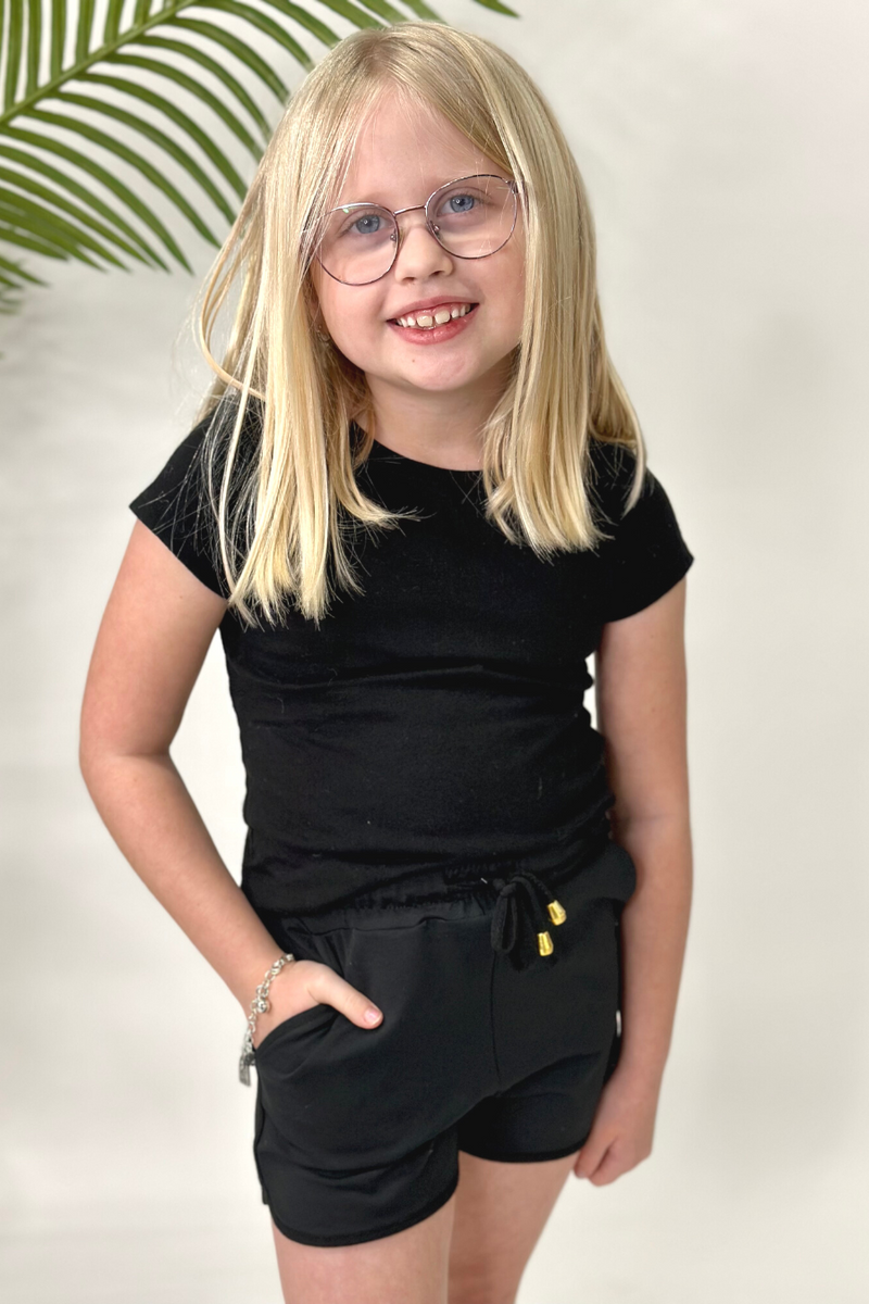 mid-rise relaxed fit activewear shorts with side pockets and a tie waist drawstring with gold bead accents, designed on a solid black print fabric and black trim