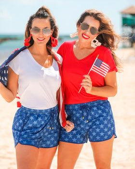 mid-rise relaxed fit activewear shorts with side pockets and a tie waist drawstring with gold bead accent on a blue star patterned fabric and blue trim