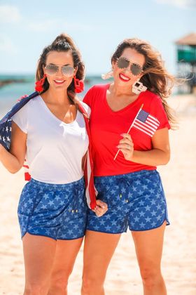 mid-rise relaxed fit activewear shorts with side pockets and a tie waist drawstring with gold bead accent on a blue star patterned fabric and blue trim