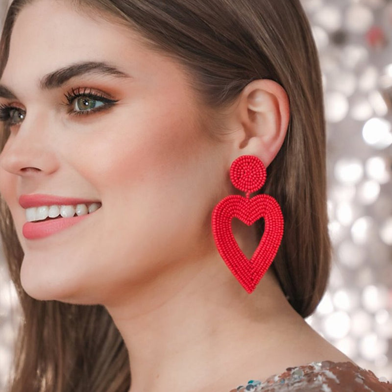 red beaded post stud earrings with matching beaded heart, a comfort replacement earring back, and a plastic disk stopper style in silver and gold