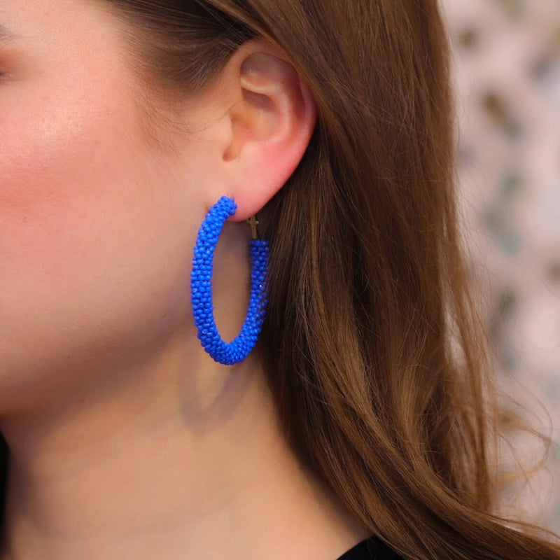 lightweight beaded hoop earrings with a classic circular silhouette in vibrant blue