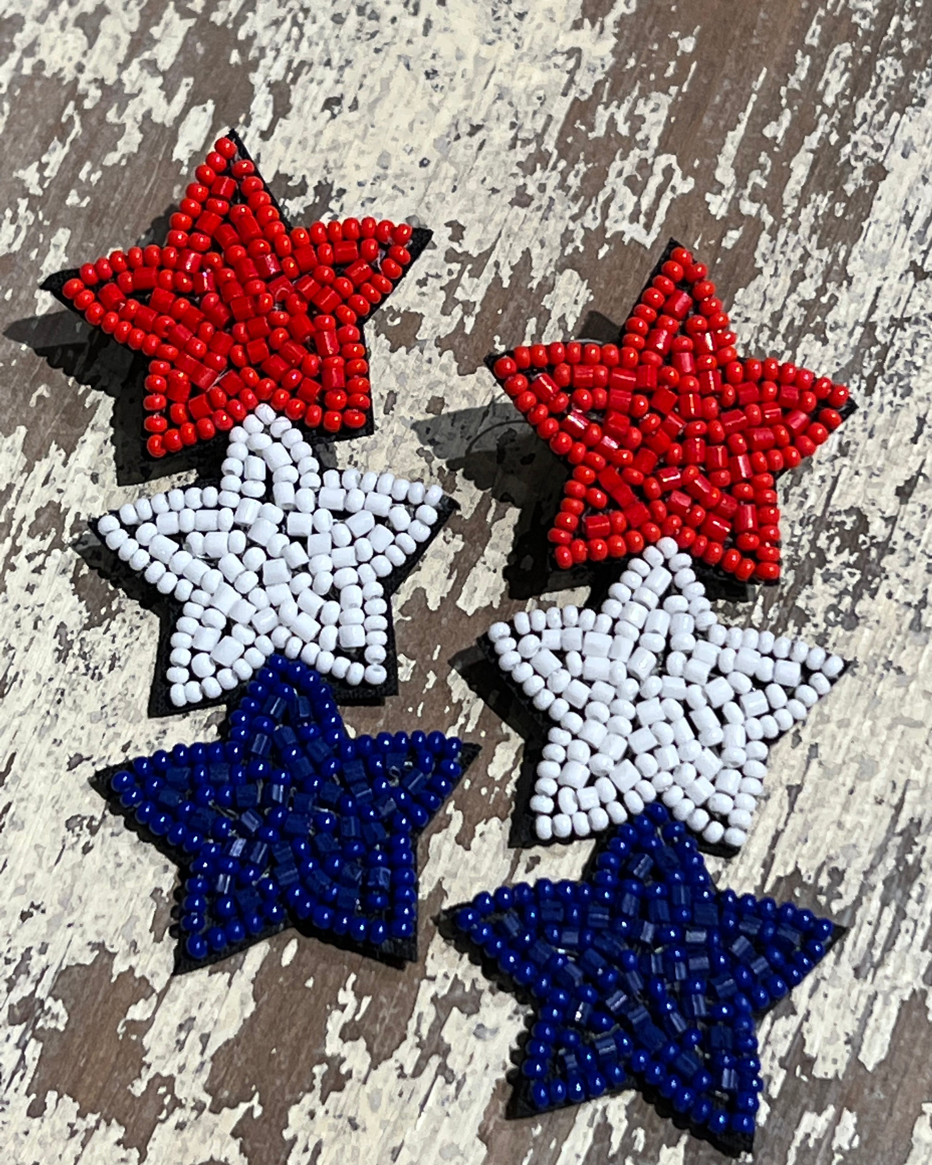 Americana-inspired beaded star earrings with red, white, and blue details, felt backing, and a push-back closure